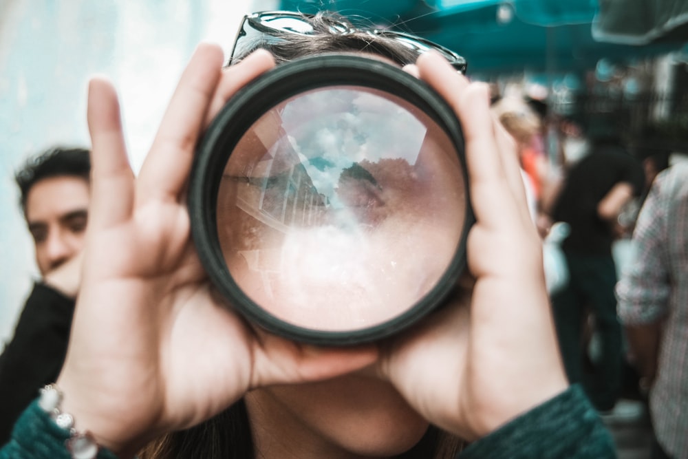 person holding lens during daytime