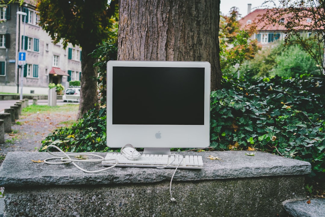 white iMac and white keyboard on concrete bench