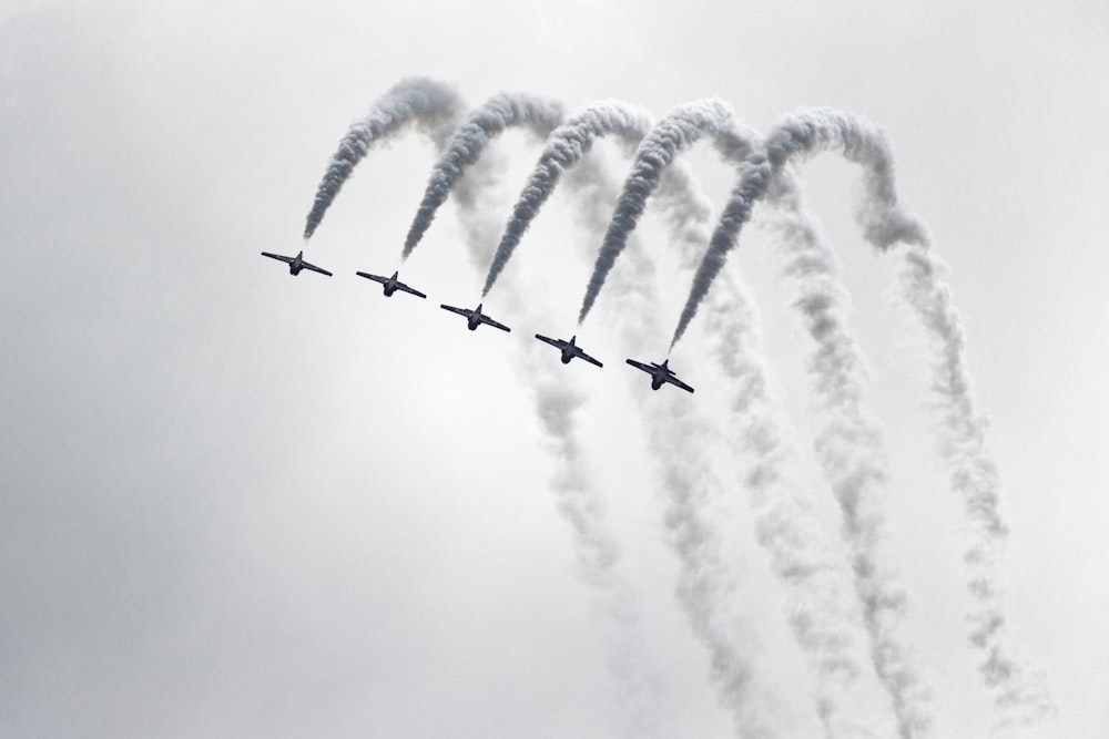 Cinq avions à réaction en niveaux de gris