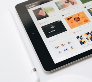 turned-on black iPad and white Apple Pencil
