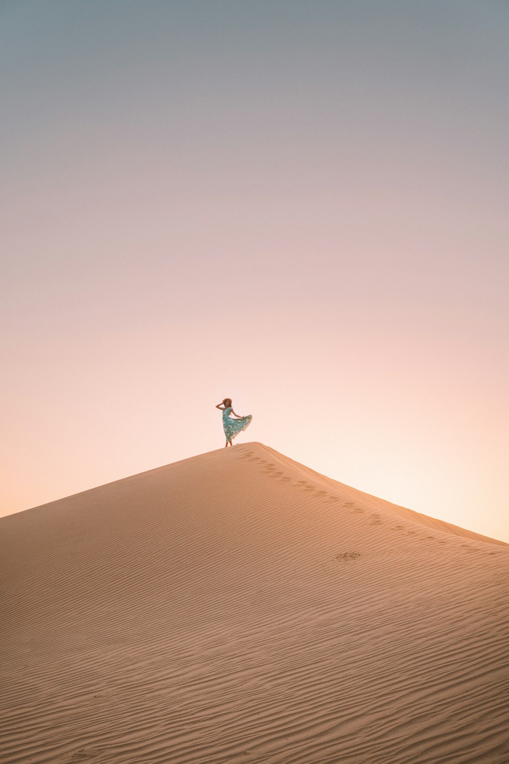 사막 언덕에 서 있는 여자