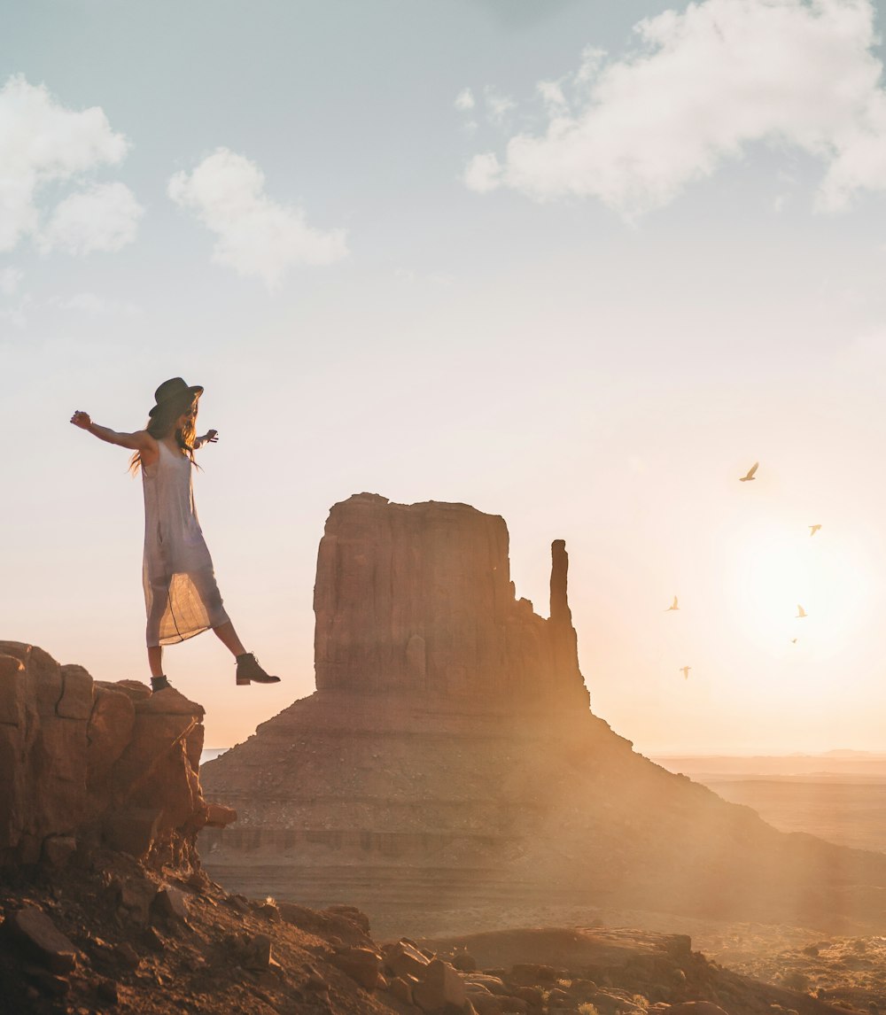 woman standing on rock during golden hour