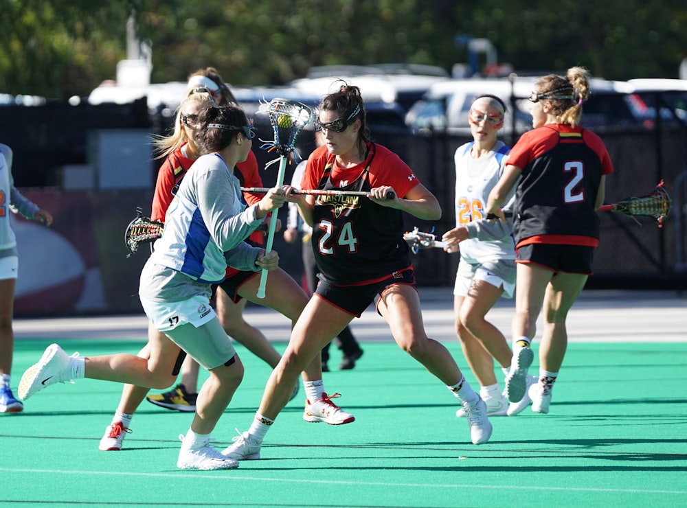 women playing lacrosse during day time