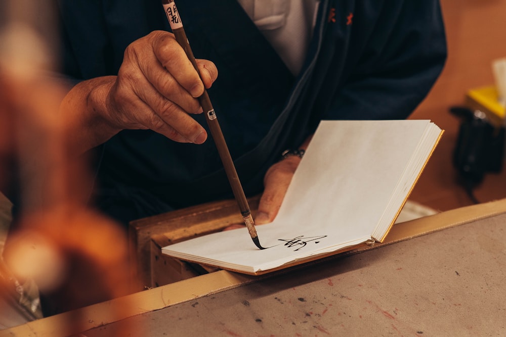 person writing on book