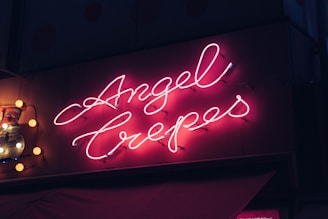 A vibrant neon sign showcasing the brand name 'Angel Family Laser'.