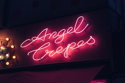 A vibrant neon sign showcasing the brand name 'Angel Family Laser'.