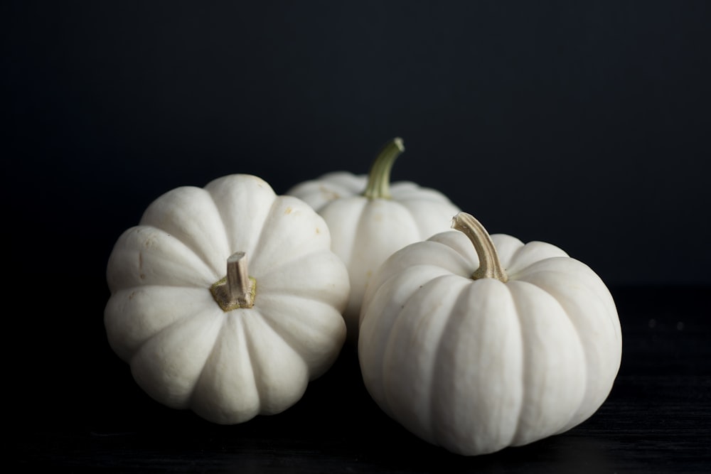 three white squash on black background