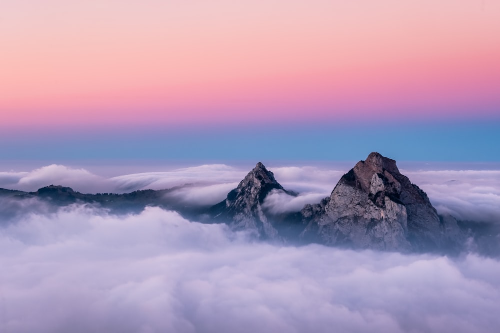 Una montagna con un cielo rosa sopra le nuvole