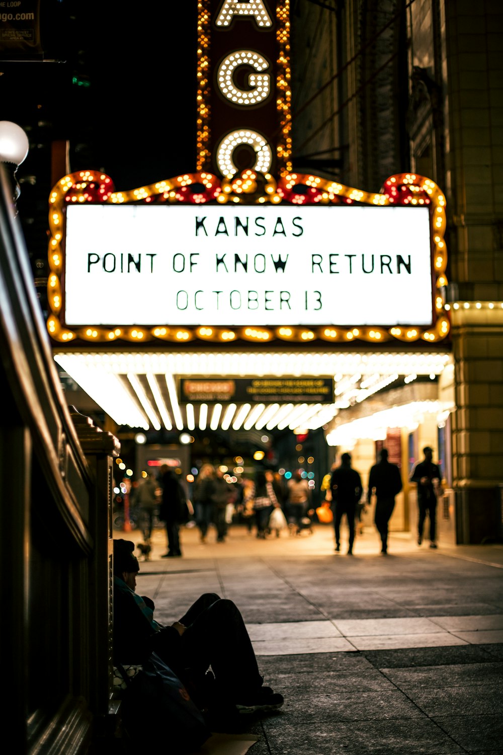 people walking under LED signage at night