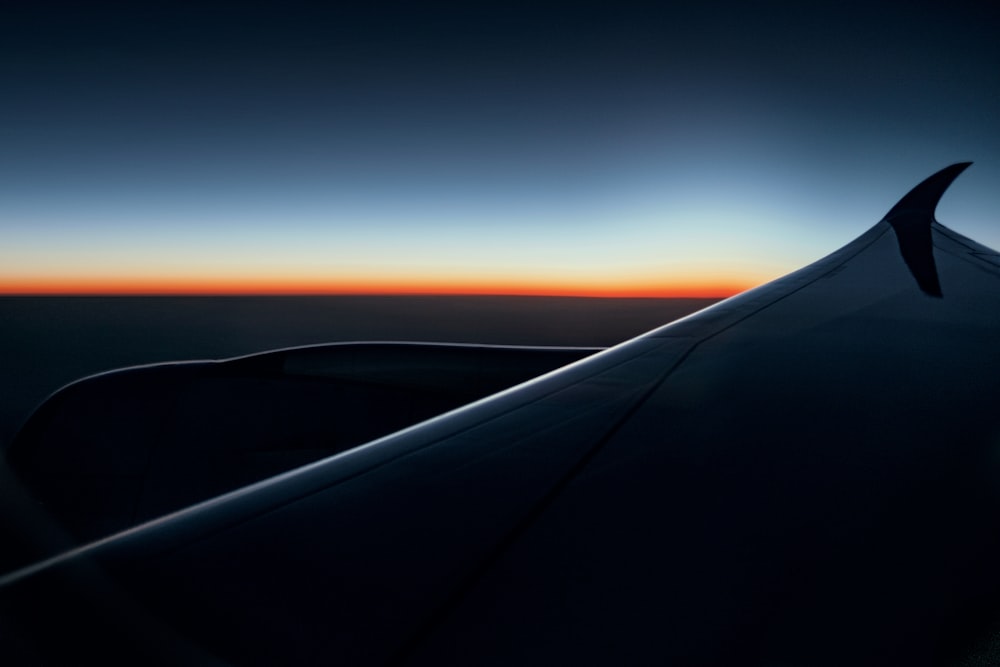 the wing of an airplane as the sun sets