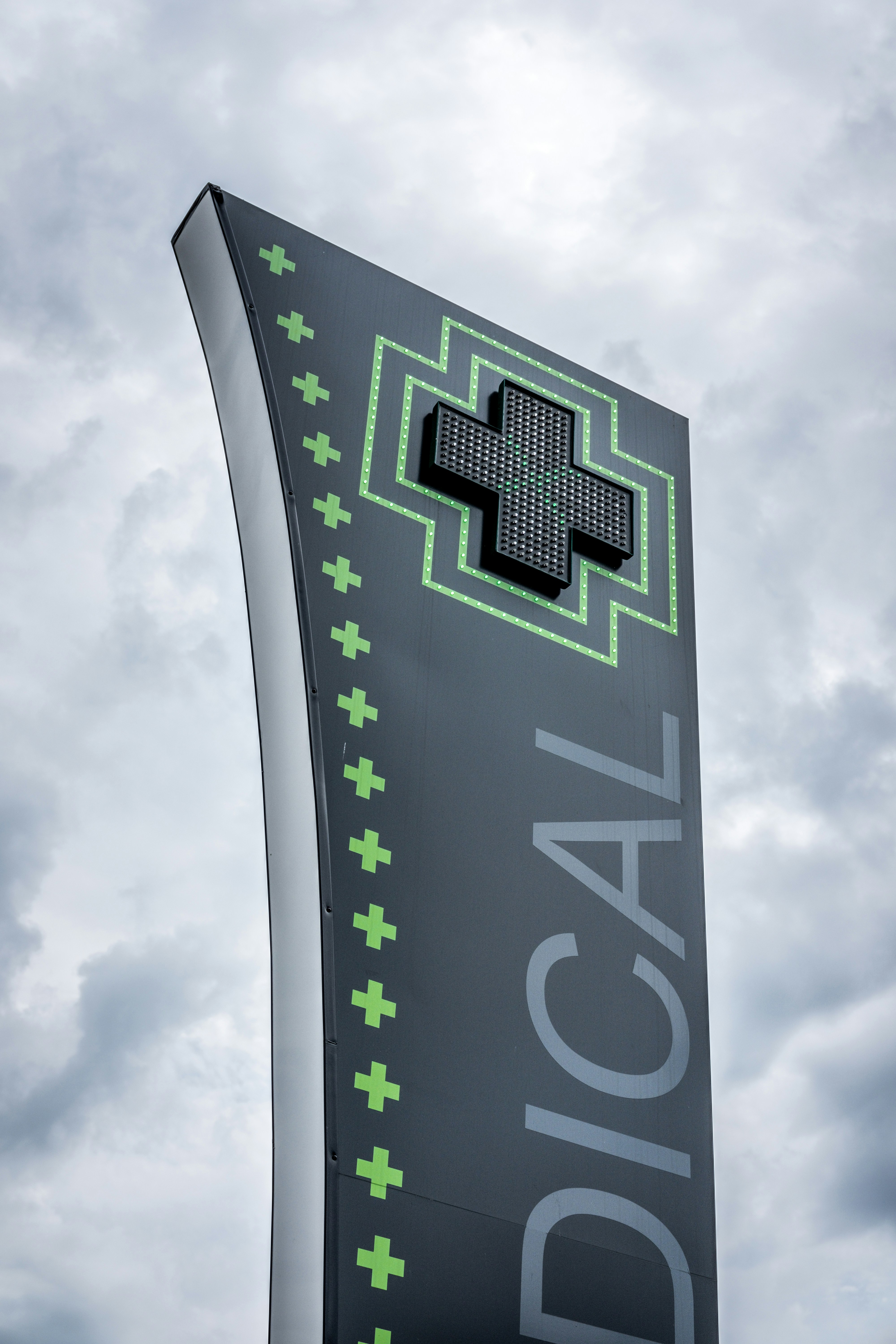 Sportmed Chiropractic logo, a stylized spine with a medical cross