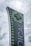 A tall, modern sign with a dark background featuring a large, illuminated green cross at the top. The word 'MEDICAL' is written vertically in large letters. Smaller green crosses line the side of the sign, set against a cloudy sky.