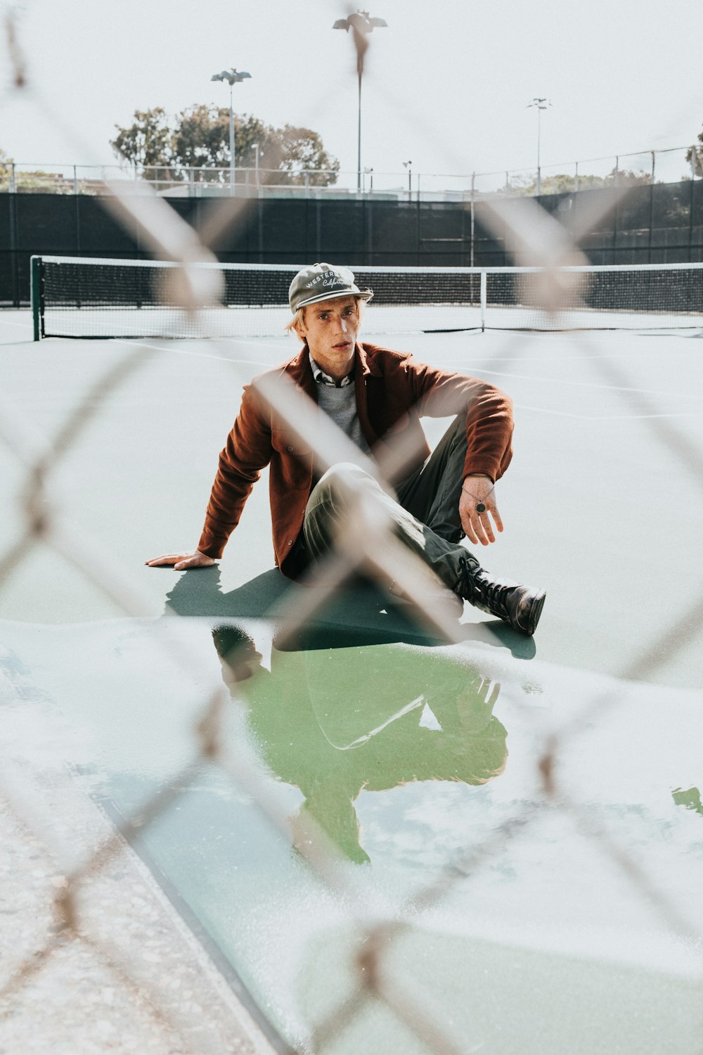 man sitting on concrete ground during daytime