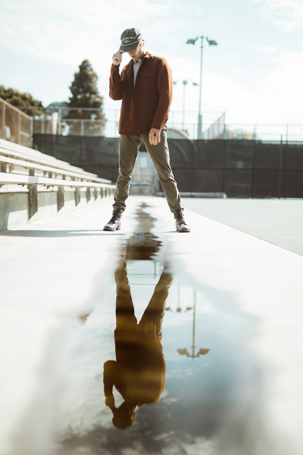 man standing on road with water reflection during daytime