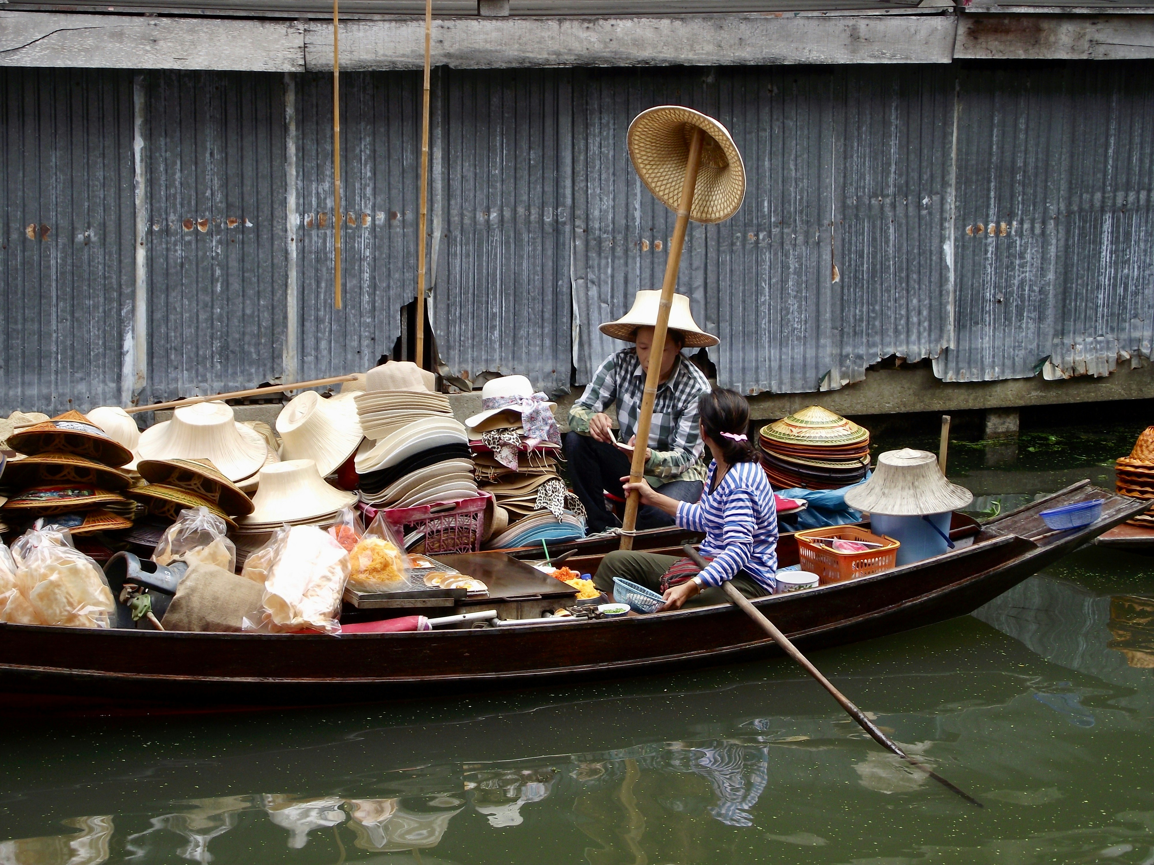 two women on boat beside hat lot
