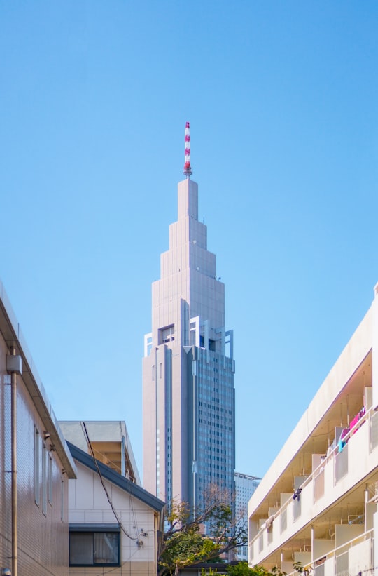 white tower building under blue sky in Shinjuku Gyoen National Garden Japan