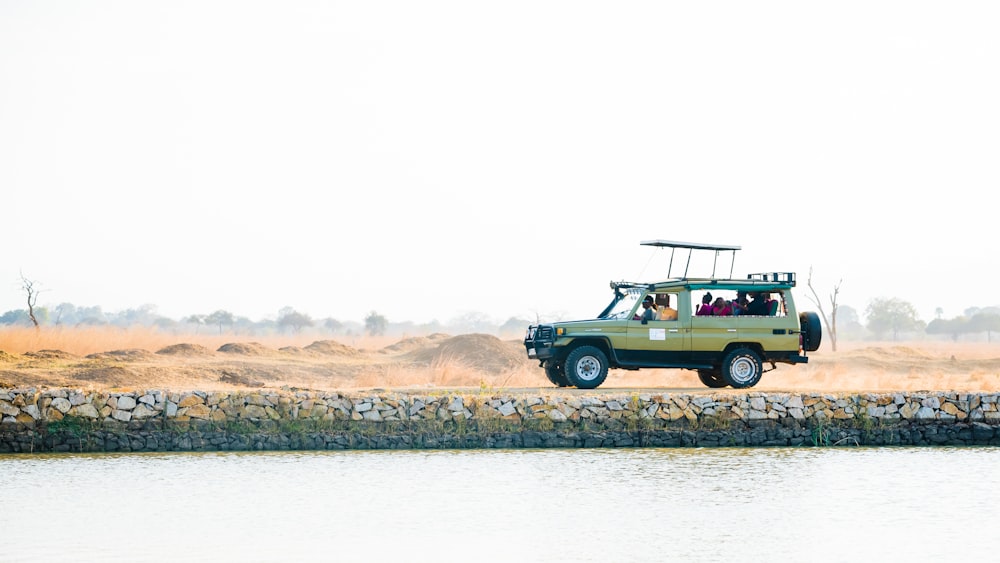 SUV grigio vicino allo specchio d'acqua sotto il cielo sereno