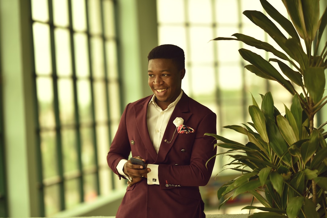 man holding smartphone while smiling,