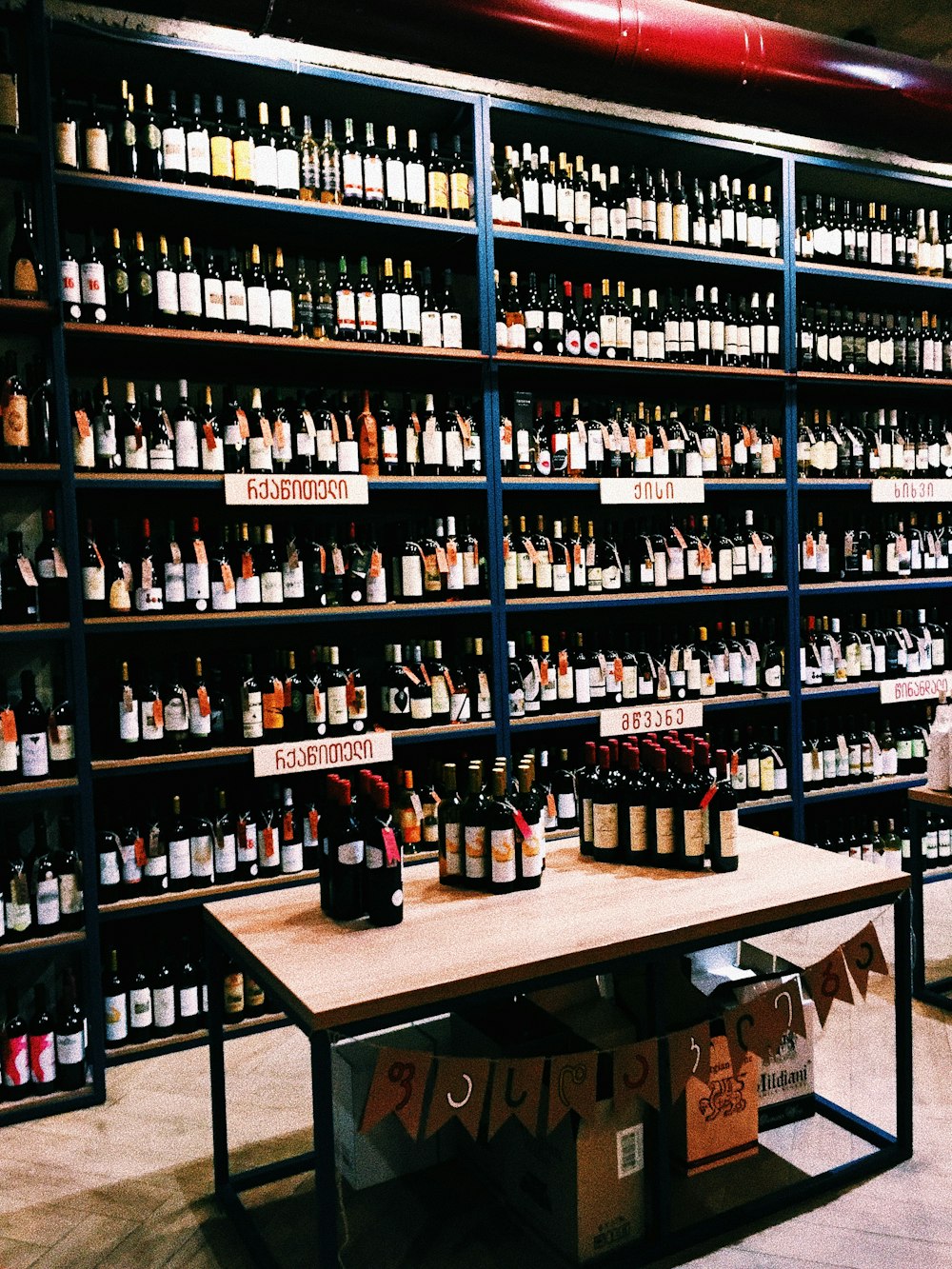 assorted-label wine bottle lot on table and shelves