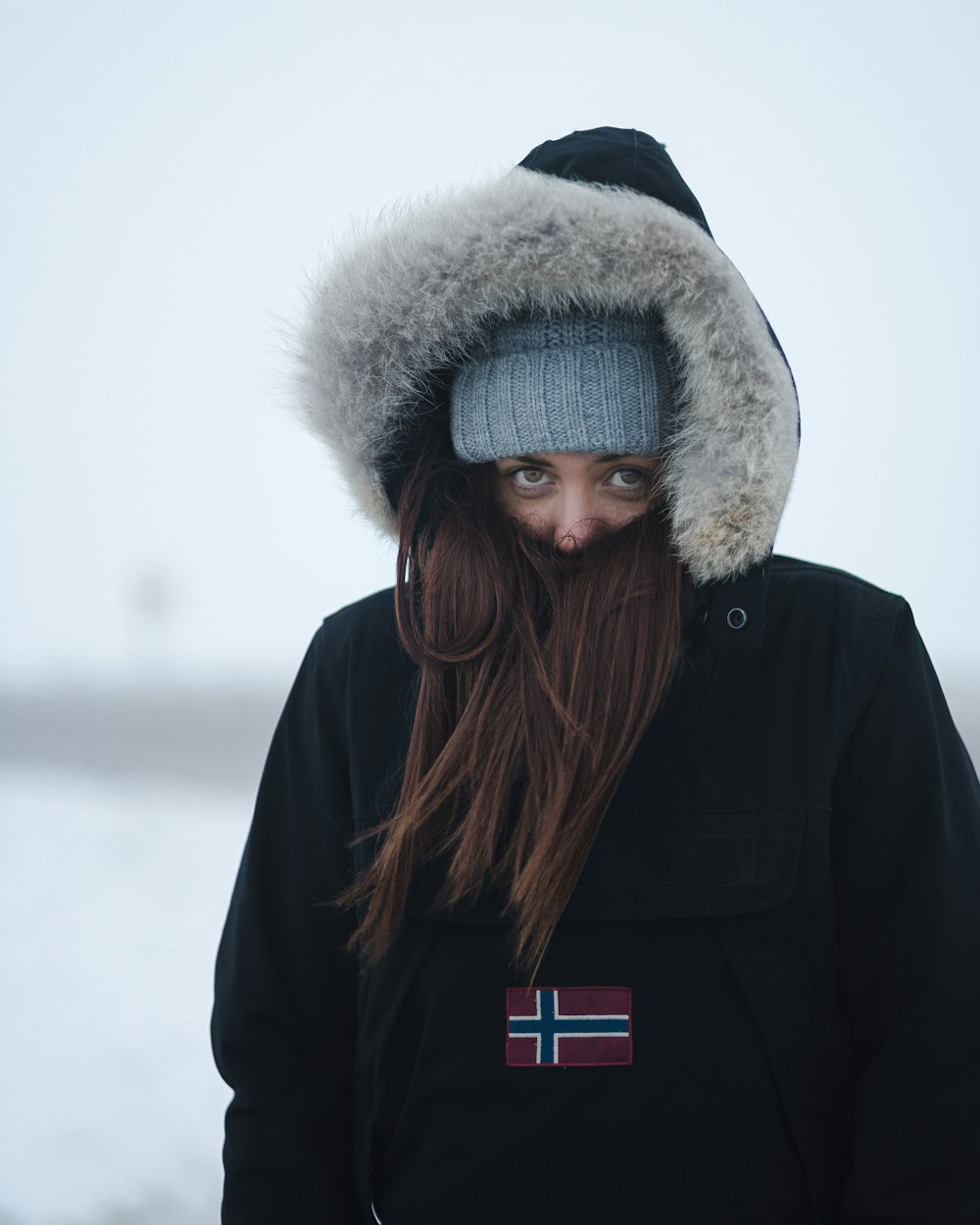 woman standing while covered in parka coat