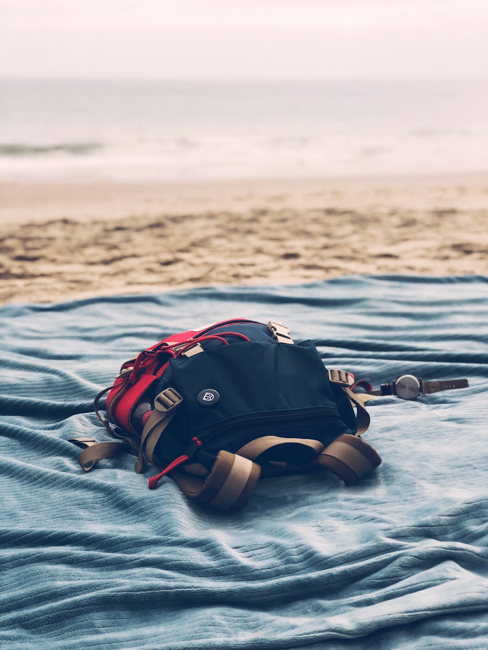 black bag on gray textile near seashore