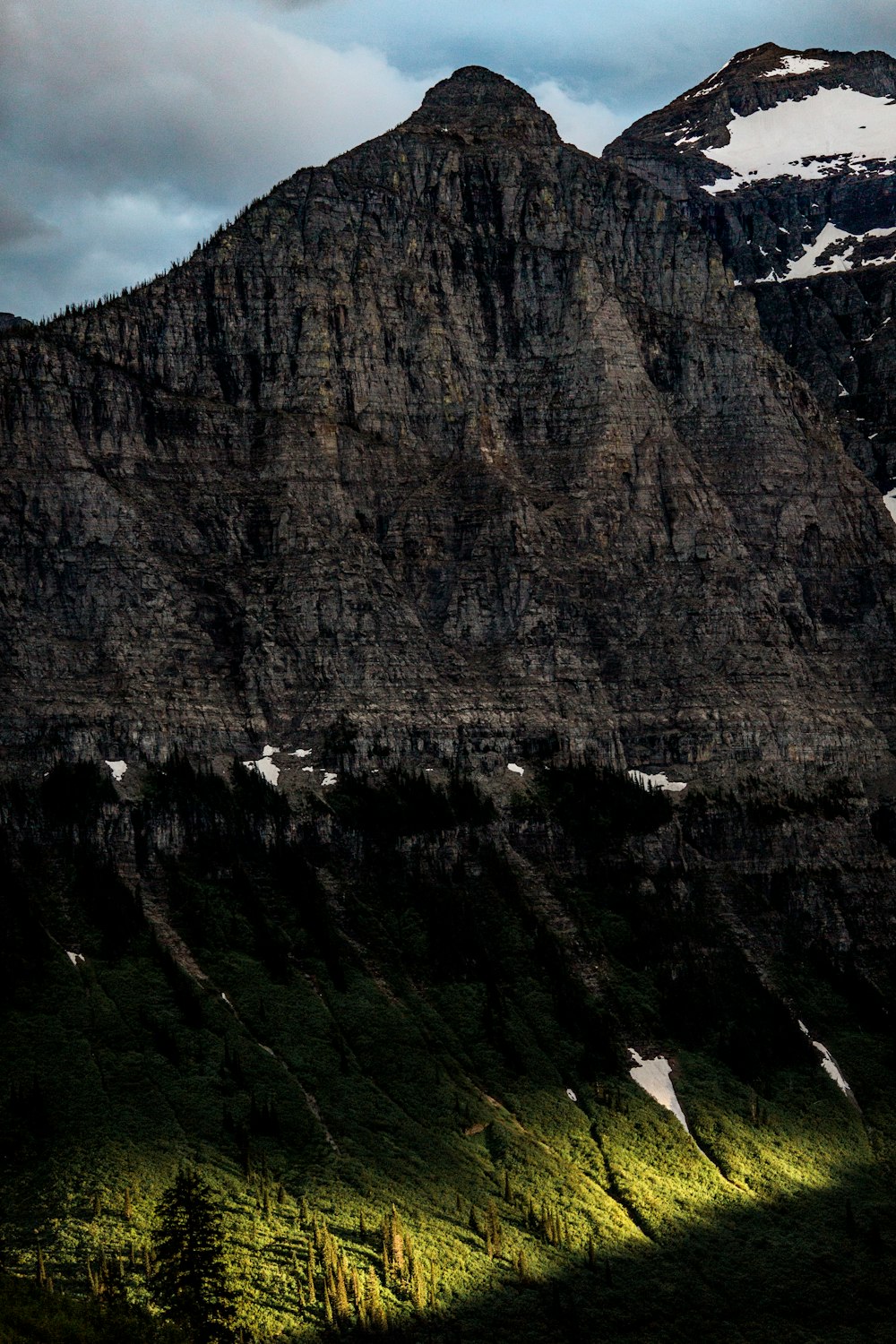 gray rocky mountain under cloudy sky during daytime