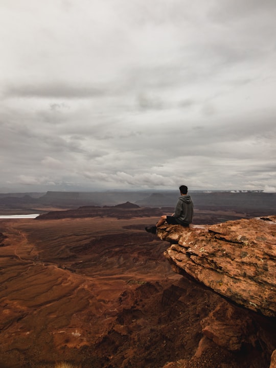 man sitting on cliff in Moab United States