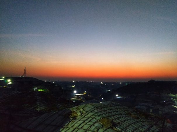 A panoramic shot of a city skyline at dusk with a rooftop concert in full swing.