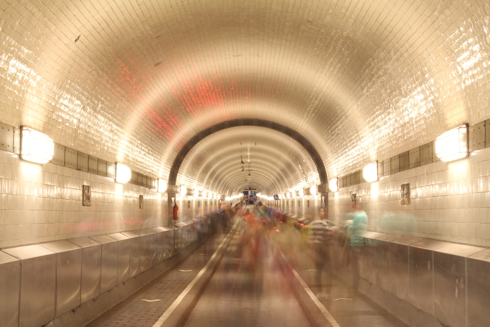 a group of people walking down a subway tunnel