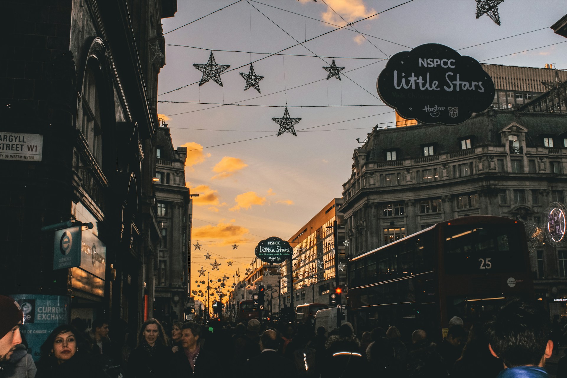 A vibrant cityscape at sunset with tourists enjoying a guided bus tour along historic streets.
