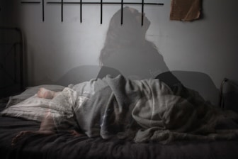 shadow of woman sitting up in bed, not sleeping