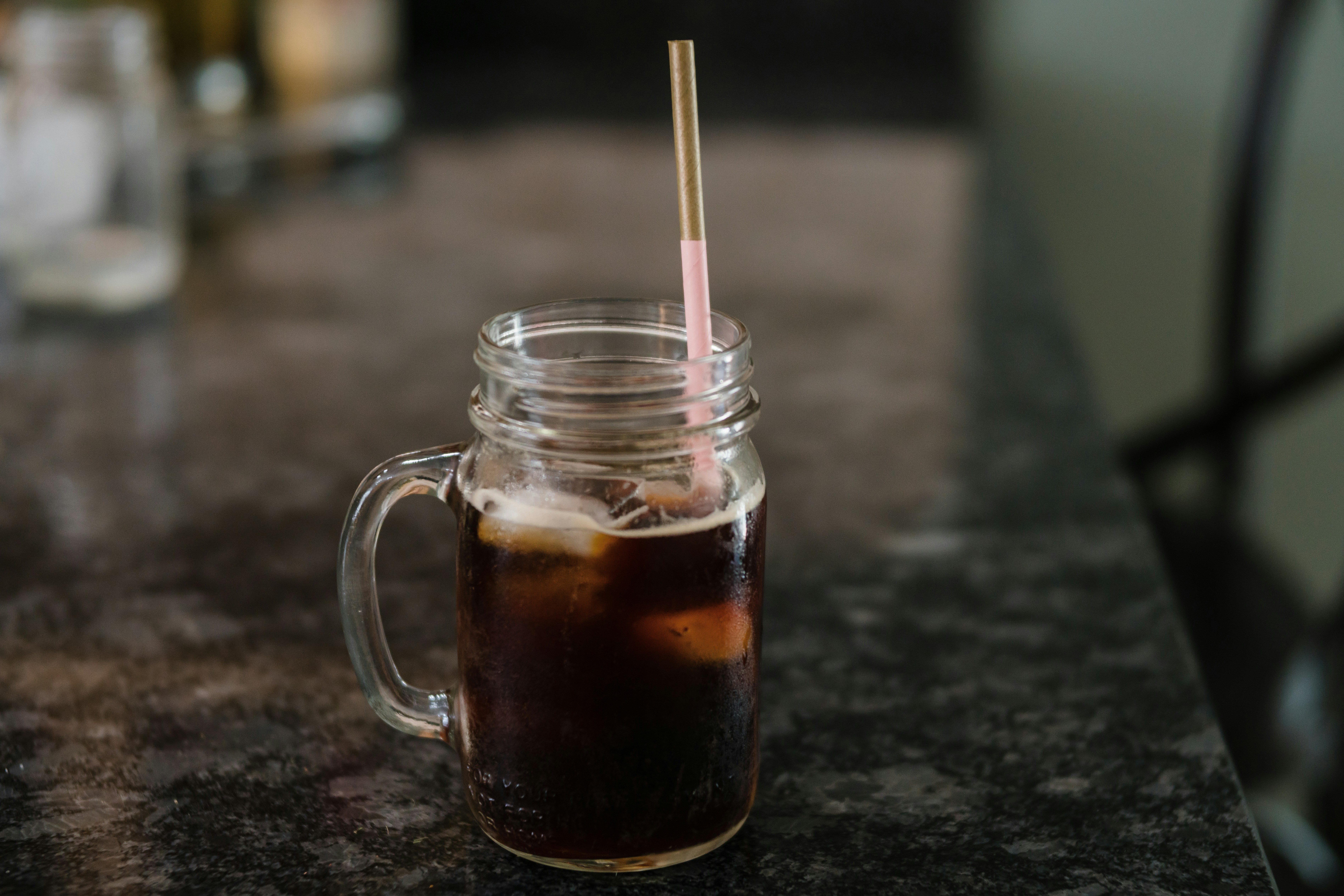 Clear Glass Mason Jar Filled With Black Liquid On Gray Granite
