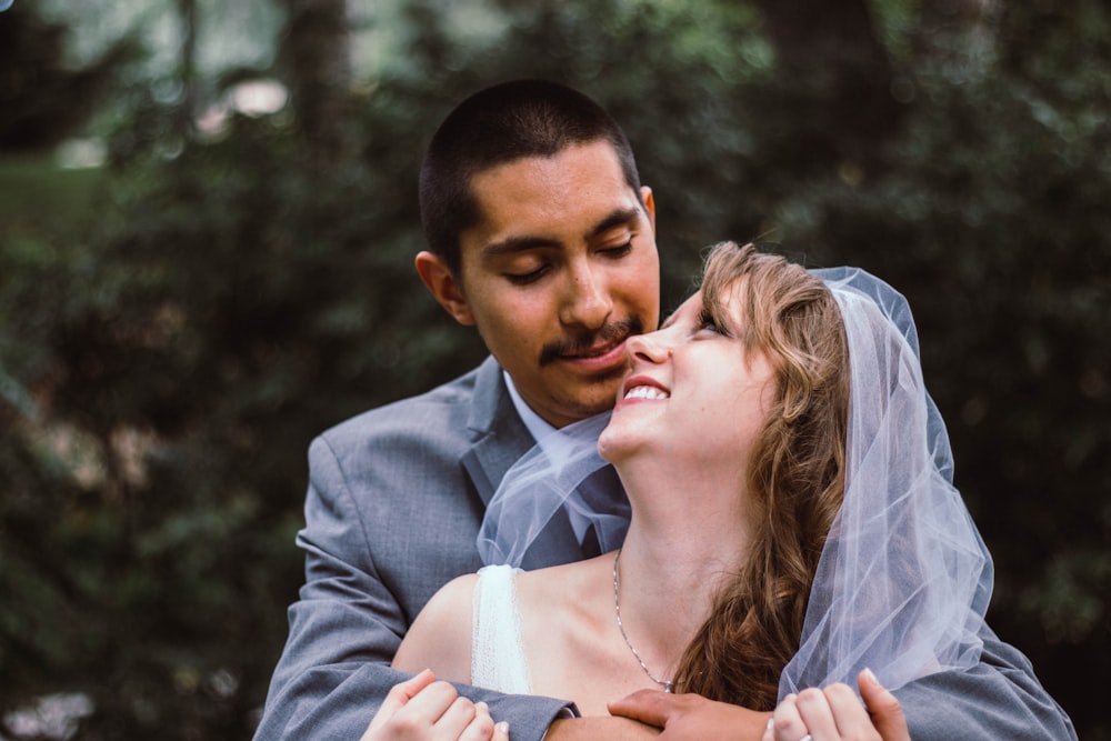 selective focus photography of man and woman on wedding suits