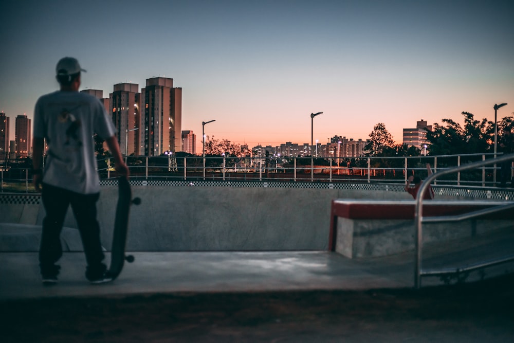 man standing on skatepark near high rise building at daytime