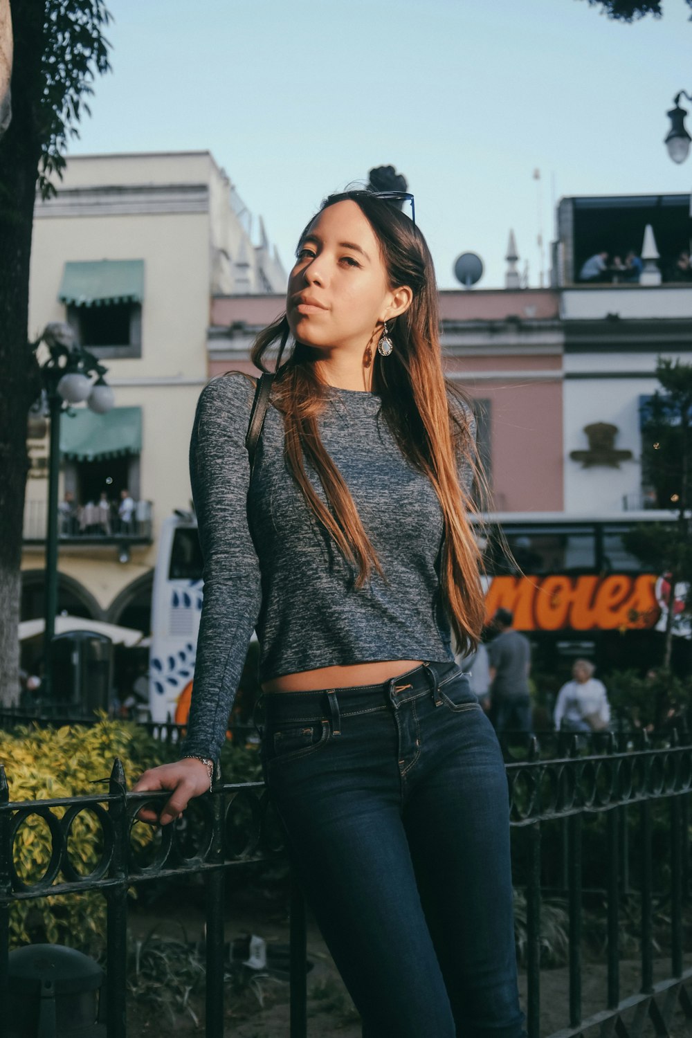 woman leaning on black metal fence