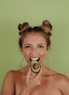 woman holding sliced avocado