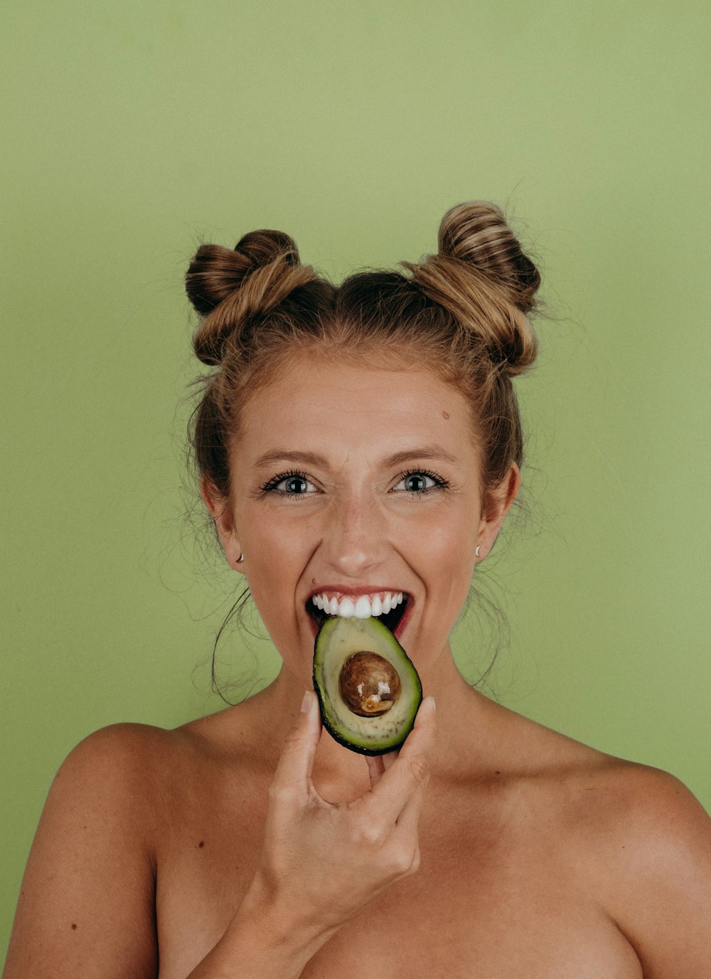 Mujer sosteniendo aguacate en rodajas