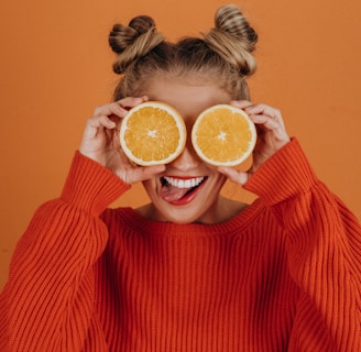 woman in red knit sweater holding lemon