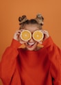 woman in red knit sweater holding lemon