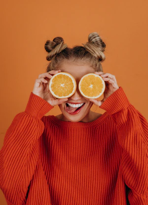woman in red knit sweater holding lemon