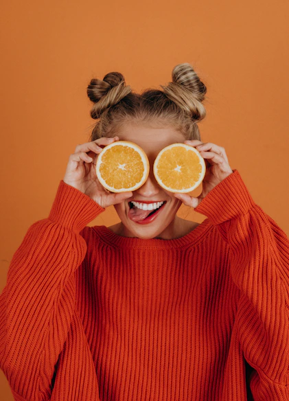 woman in red knit sweater holding lemon