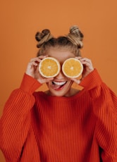 woman in red knit sweater holding lemon