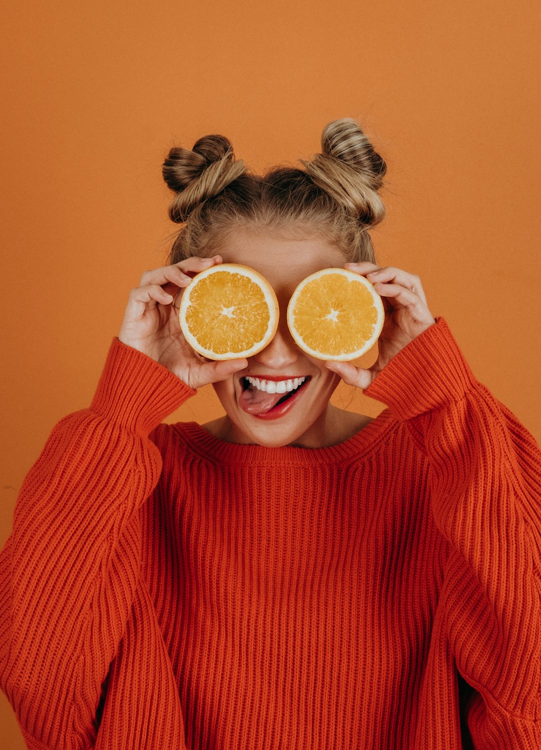 woman in red knit sweater holding lemon