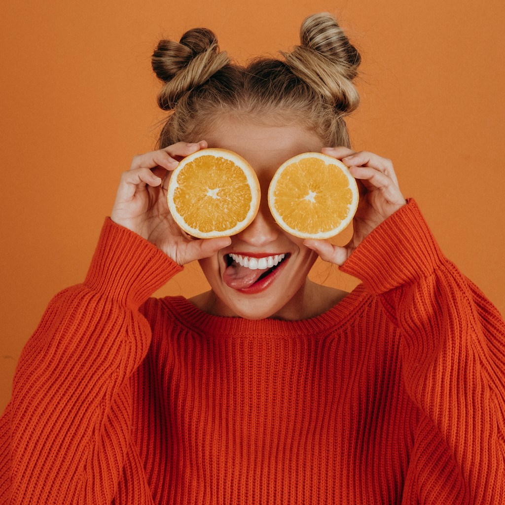 woman in red knit sweater holding lemon