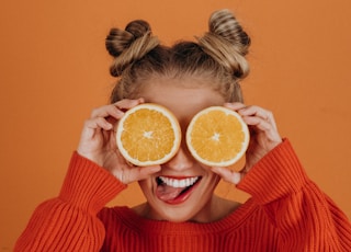 woman in red knit sweater holding lemon