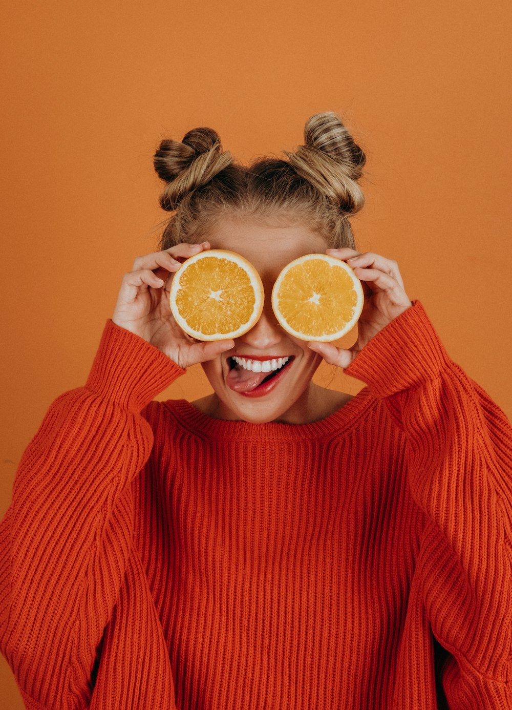 woman in red knit sweater holding lemon