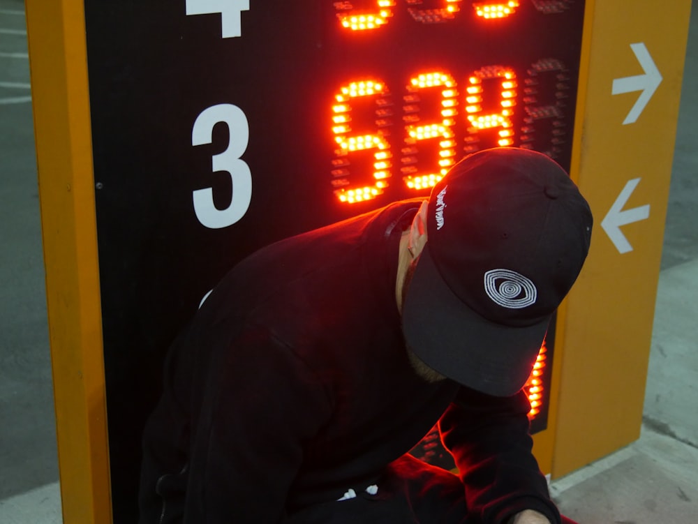 man sitting beside digital signage