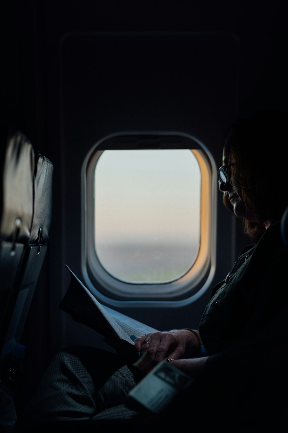 Mujer sentada y leyendo un libro en el avión de pasajeros