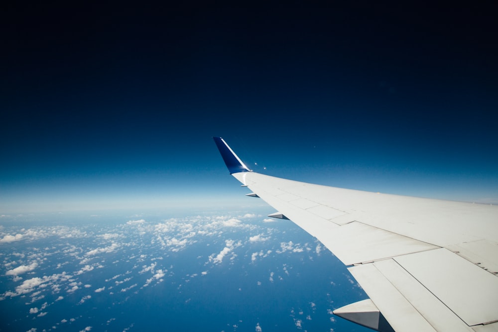 white airliner left wing flying in sky