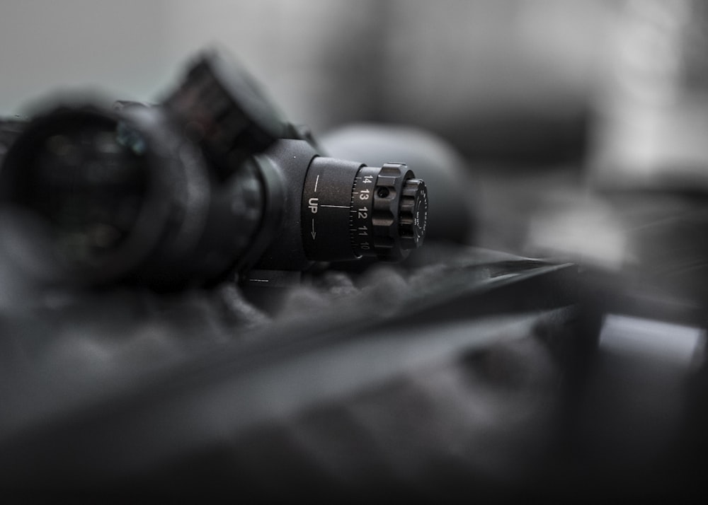 black rifle scope on selective focus photography